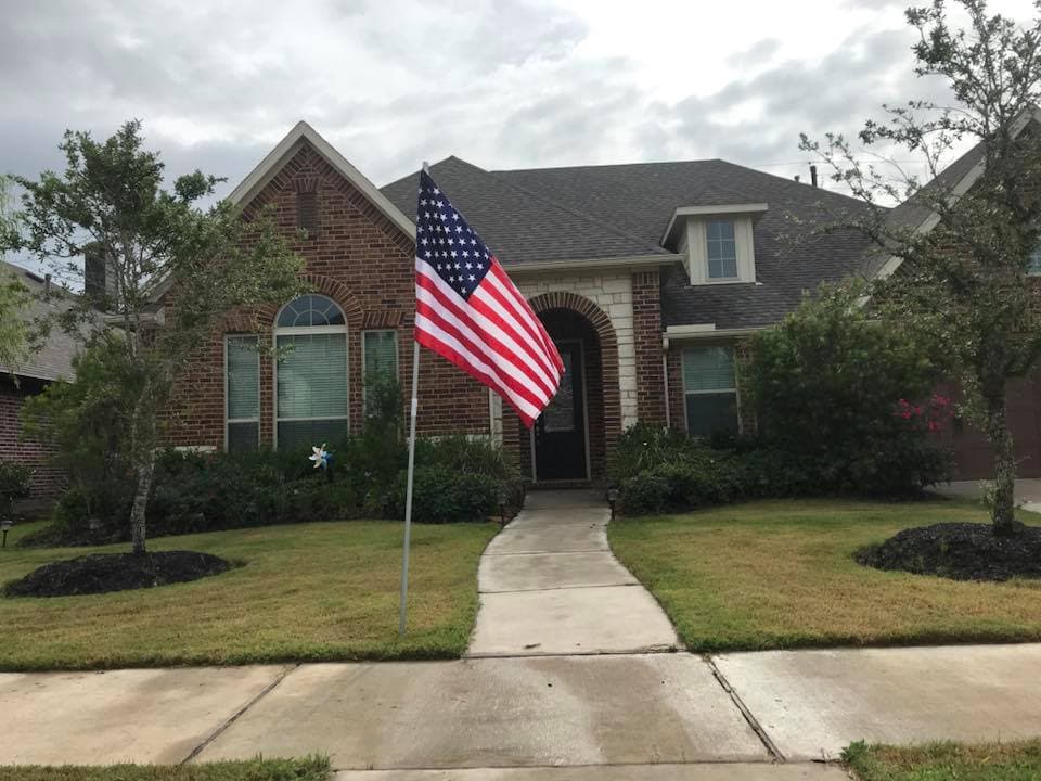 American flag proudly displayed in a front yard